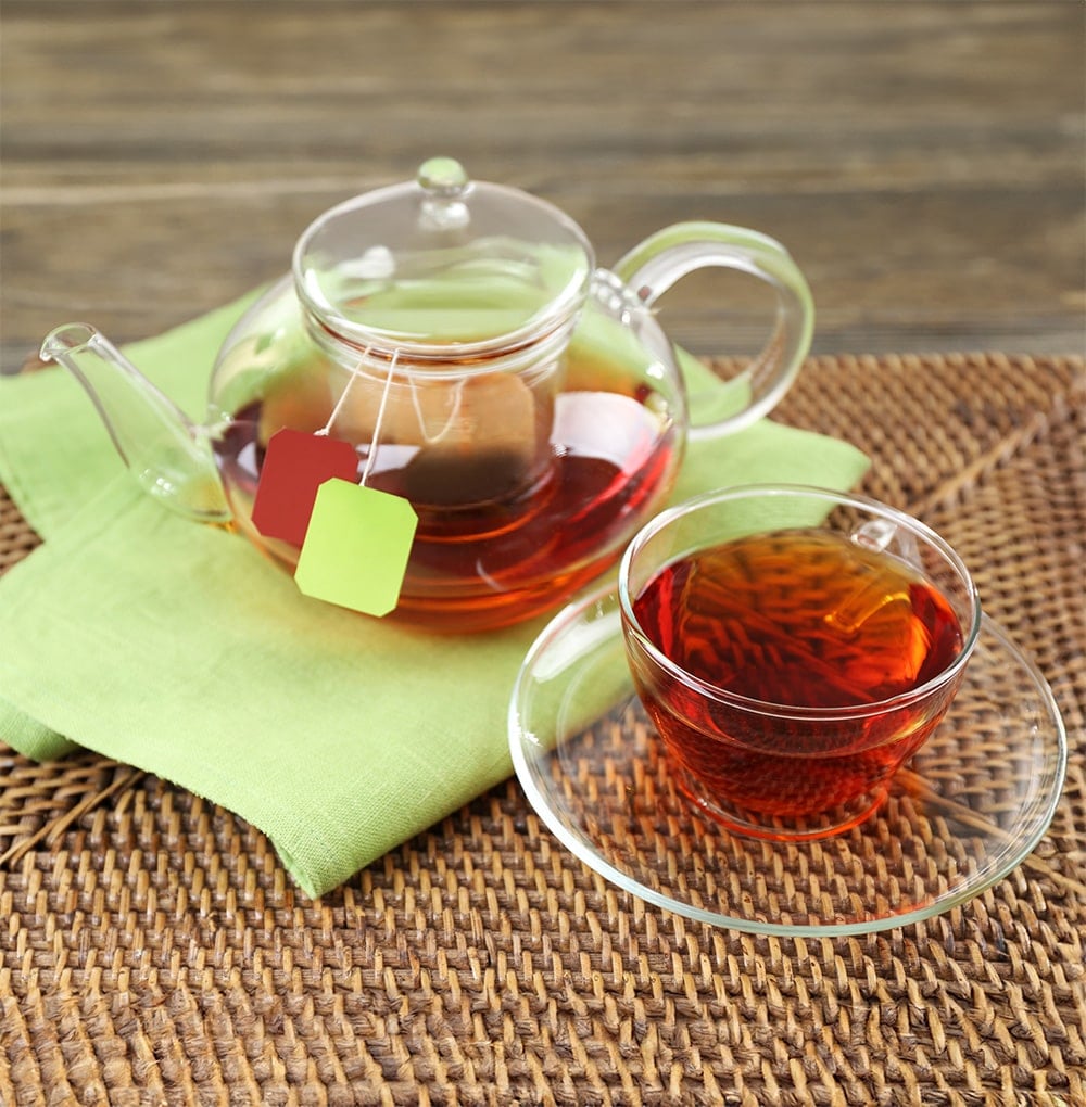 A cup of tea with a kettle on the table