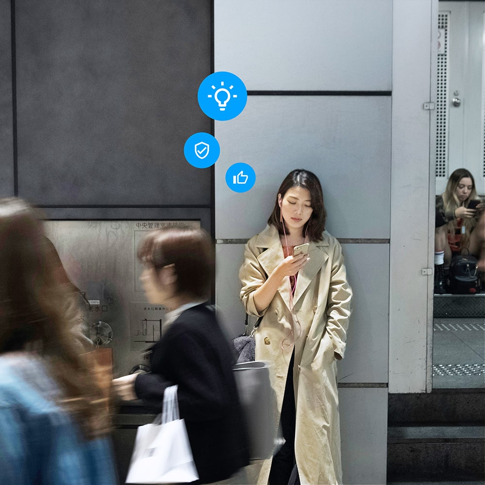 Woman standing in the street, holding a phone and looking at the phone screen