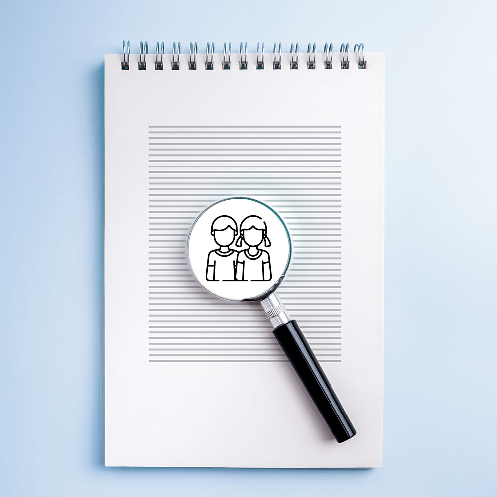 Illustration of a note block and a a magnifying glass on a drawing of two children